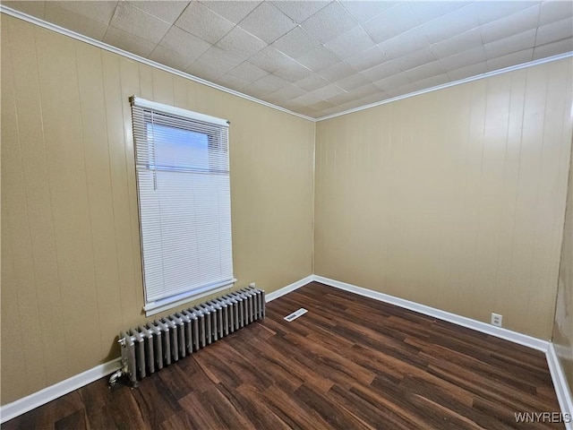 2207 Linwood Ave, Niagara Falls, NY 14305 - unfurnished room with radiator heating unit, dark wood-type flooring, ornamental molding, and baseboards