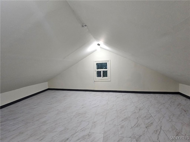 2207 Linwood Ave, Niagara Falls, NY 14305 - additional living space featuring vaulted ceiling, baseboards, and marble look tile flooring