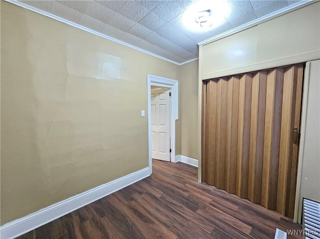 2207 Linwood Ave, Niagara Falls, NY 14305 - unfurnished bedroom featuring dark wood finished floors, baseboards, crown molding, and a closet