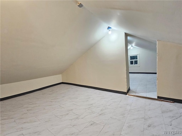 2207 Linwood Ave, Niagara Falls, NY 14305 - additional living space featuring vaulted ceiling, marble look tile flooring, and baseboards