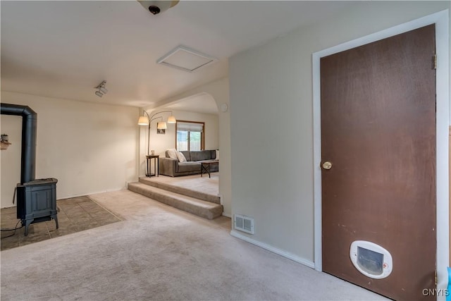 163 Maple St, Le Ray, NY 13612 - unfurnished living room featuring carpet floors, a wood stove, and baseboards