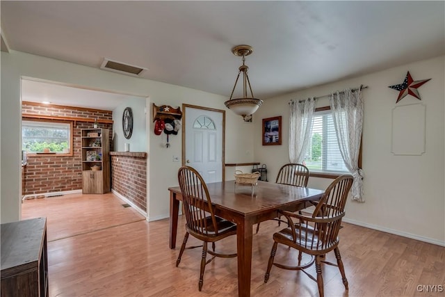 163 Maple St, Le Ray, NY 13612 - dining area featuring light wood finished floors, baseboards, and brick wall