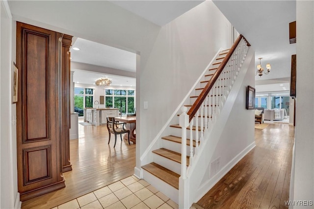 1225 W Arnold Dr, Hamburg, NY 14085 - staircase featuring a chandelier, wood finished floors, baseboards, and recessed lighting