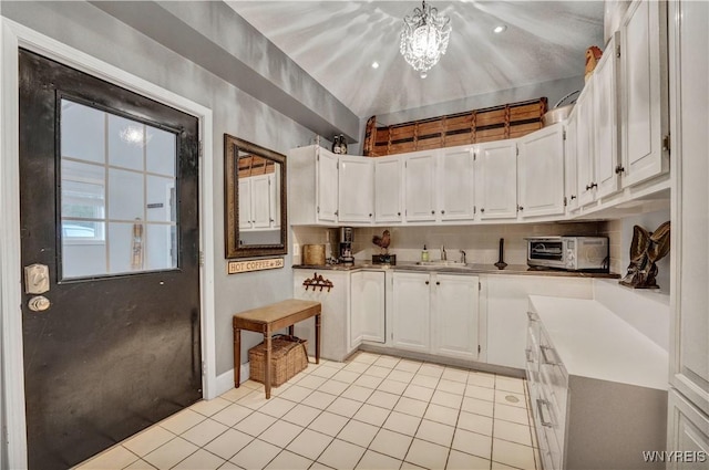1225 W Arnold Dr, Hamburg, NY 14085 - kitchen with light tile patterned floors, a sink, white cabinetry, baseboards, and a chandelier