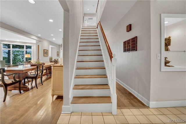 1225 W Arnold Dr, Hamburg, NY 14085 - stairway featuring baseboards, wood finished floors, and recessed lighting