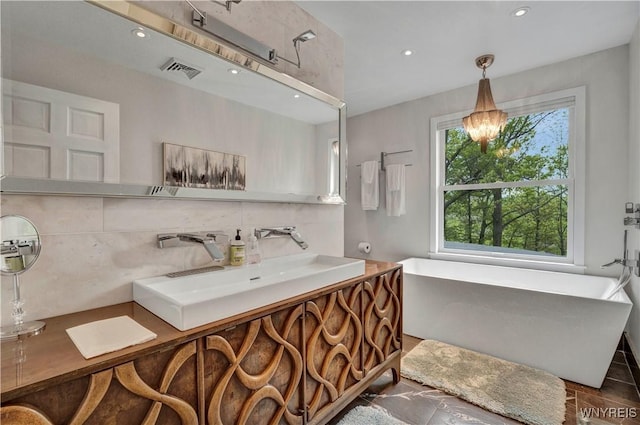1225 W Arnold Dr, Hamburg, NY 14085 - bathroom with a soaking tub, decorative backsplash, vanity, recessed lighting, and a chandelier