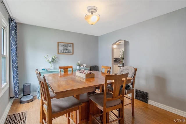 229 Brookfield Rd, Salina, NY 13211 - dining area with arched walkways, light wood-type flooring, and baseboards