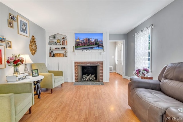 5024 Callan Dr, Lewiston, NY 14092 - living area with wood finished floors, built in shelves, a brick fireplace, and baseboards