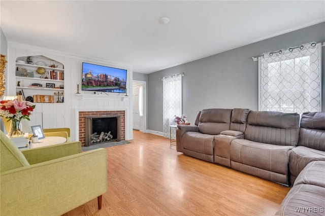 5024 Callan Dr, Lewiston, NY 14092 - living area with light wood finished floors, a brick fireplace, built in features, and baseboards