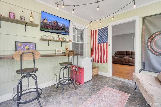 5024 Callan Dr, Lewiston, NY 14092 - recreation room featuring a dry bar, ornamental molding, stone finish floors, baseboards, and rail lighting