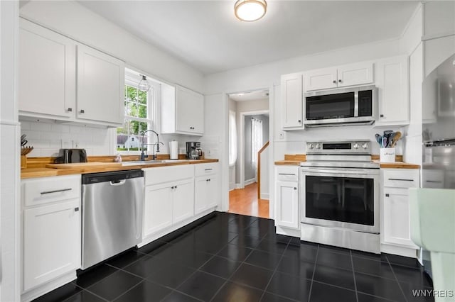 5024 Callan Dr, Lewiston, NY 14092 - kitchen featuring stainless steel appliances, a sink, butcher block countertops, and white cabinetry