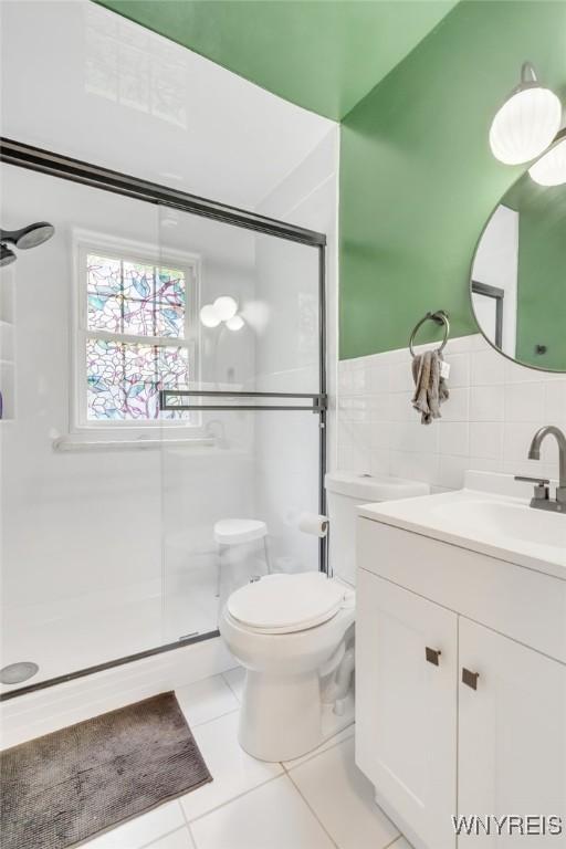 5024 Callan Dr, Lewiston, NY 14092 - bathroom with a stall shower, vanity, toilet, tile patterned flooring, and tile walls