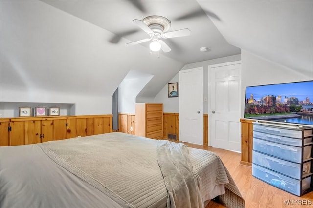 5024 Callan Dr, Lewiston, NY 14092 - bedroom featuring wainscoting, vaulted ceiling, light wood-style flooring, and ceiling fan