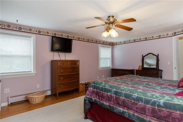 61 Brookside Cir, Big Flats, NY 14903 - bedroom with multiple windows, wood finished floors, a ceiling fan, and a baseboard radiator