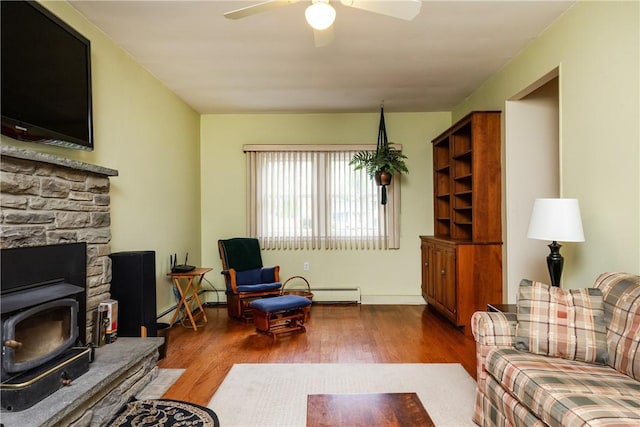 61 Brookside Cir, Big Flats, NY 14903 - living area featuring a wood stove, wood finished floors, ceiling fan, and a baseboard heating unit