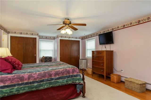 61 Brookside Cir, Big Flats, NY 14903 - bedroom with wood finished floors, two closets, baseboard heating, and a ceiling fan