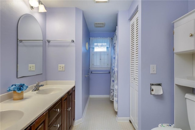 61 Brookside Cir, Big Flats, NY 14903 - bathroom featuring double vanity, baseboards, and toilet