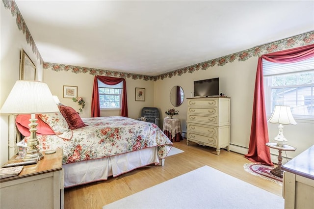 126 True Hickory Dr, Greece, NY 14615 - bedroom with multiple windows, wood finished floors, and a baseboard heating unit