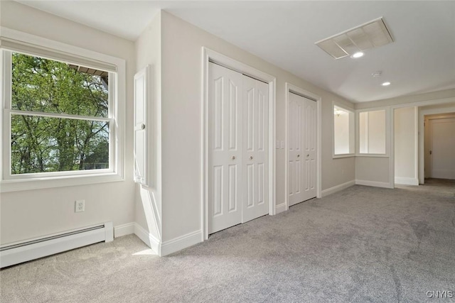 97 Burtis Point Rd, Owasco, NY 13021 - unfurnished bedroom featuring multiple closets, a baseboard heating unit, carpet floors, and baseboards
