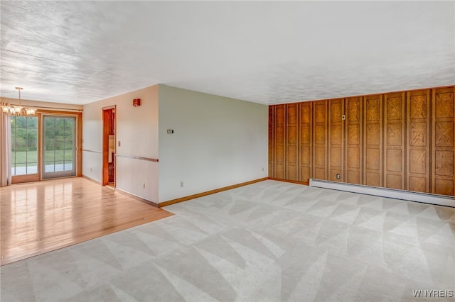 7415 Colonial Dr, Niagara, NY 14305 - unfurnished room with baseboard heating, a chandelier, baseboards, and light colored carpet