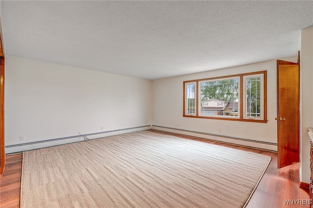 7415 Colonial Dr, Niagara, NY 14305 - spare room featuring wood finished floors, a textured ceiling, and a baseboard radiator