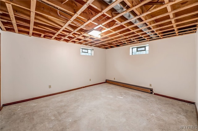 7415 Colonial Dr, Niagara, NY 14305 - below grade area featuring a baseboard heating unit, healthy amount of natural light, and baseboards