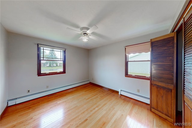 7415 Colonial Dr, Niagara, NY 14305 - empty room featuring baseboard heating, light wood-type flooring, ceiling fan, and baseboards