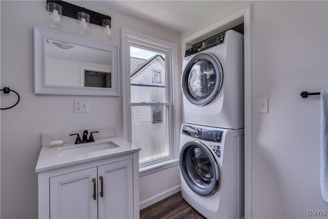 1010 Academy St, Watertown-City, NY 13601 - laundry area featuring stacked washer / dryer, a sink, plenty of natural light, and dark wood-style flooring