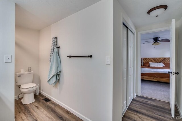 1010 Academy St, Watertown-City, NY 13601 - bathroom featuring wood finished floors, toilet, baseboards, and a ceiling fan