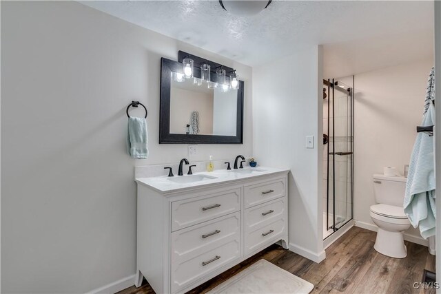 1010 Academy St, Watertown-City, NY 13601 - full bathroom with a shower stall, toilet, double vanity, wood finished floors, and baseboards