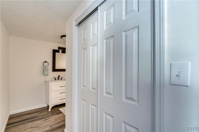 1010 Academy St, Watertown-City, NY 13601 - corridor with dark wood finished floors, baseboards, and a sink