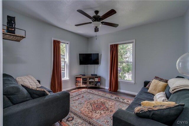 1010 Academy St, Watertown-City, NY 13601 - living room with plenty of natural light, baseboards, ceiling fan, and wood finished floors