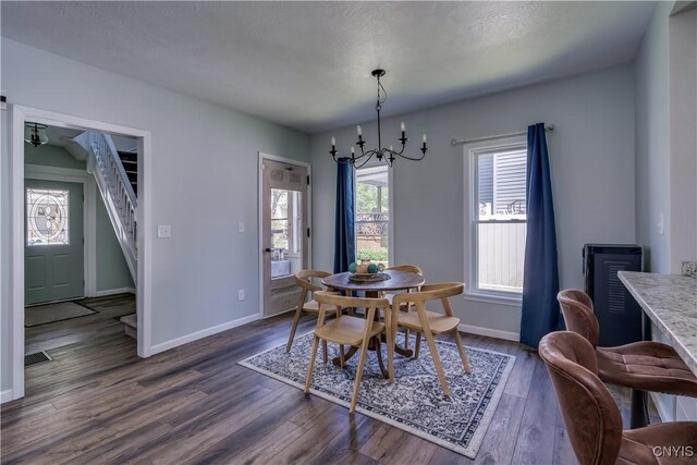 1010 Academy St, Watertown-City, NY 13601 - dining room featuring baseboards, dark wood-style floors, stairway, and a chandelier