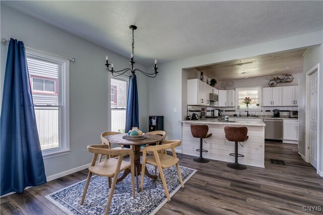 1010 Academy St, Watertown-City, NY 13601 - dining room featuring dark wood finished floors, a chandelier, and baseboards