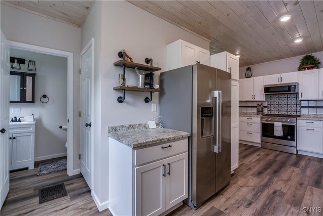 1010 Academy St, Watertown-City, NY 13601 - kitchen featuring appliances with stainless steel finishes, white cabinetry, wood finished floors, wooden ceiling, and light stone counters