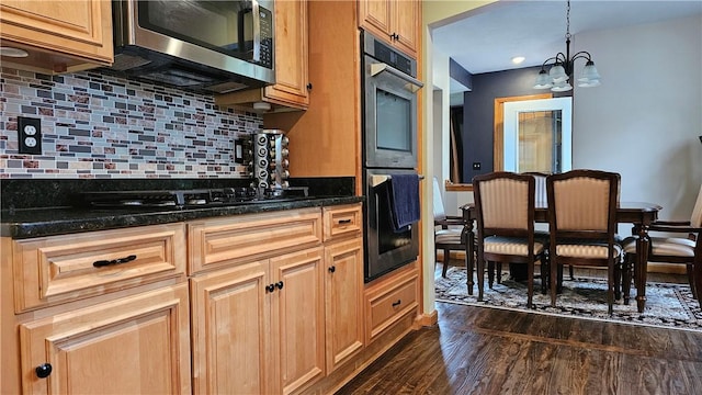 5267 Wheeler Rd, Elbridge, NY 13166 - kitchen featuring appliances with stainless steel finishes, dark wood-type flooring, a chandelier, decorative backsplash, and dark stone countertops