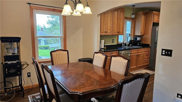 5267 Wheeler Rd, Elbridge, NY 13166 - dining room featuring arched walkways, a chandelier, dark wood-type flooring, and baseboards