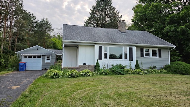 5267 Wheeler Rd, Elbridge, NY 13166 - view of front of property with an outbuilding, a chimney, asphalt driveway, a front lawn, and a detached garage