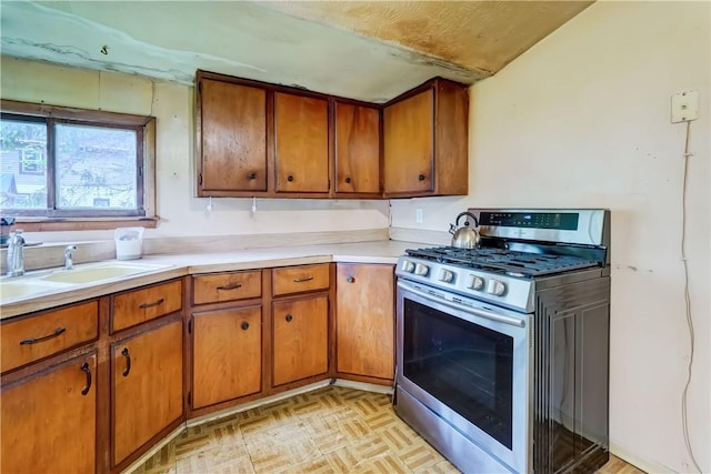 16 Welch Ave, Hamlin, NY 14470 - kitchen featuring stainless steel range with gas stovetop, brown cabinets, a sink, and light countertops