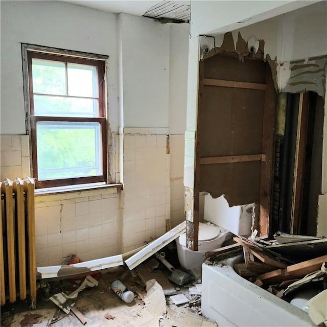 502 Partridge St, Elmira-City, NY 14904 - full bath with radiator, a wainscoted wall, a tub to relax in, and tile walls