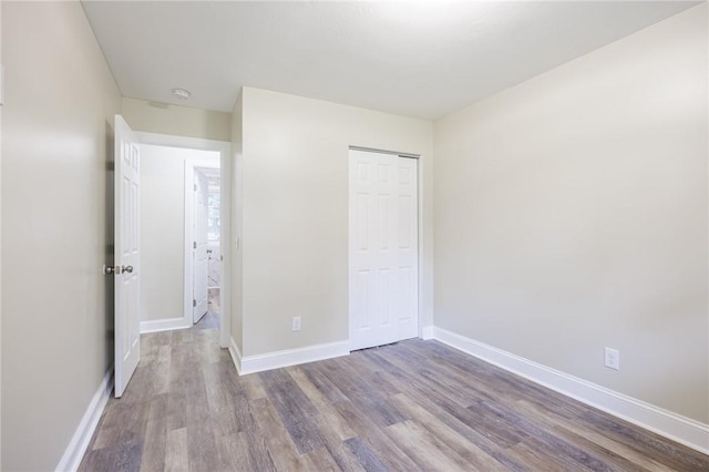 162 Berkshire Dr, Greece, NY 14626 - unfurnished bedroom featuring wood finished floors, baseboards, and a closet