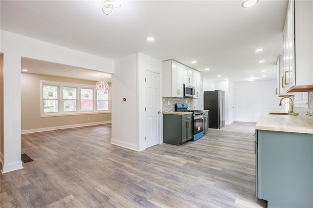 162 Berkshire Dr, Greece, NY 14626 - kitchen with stainless steel appliances, a sink, backsplash, light countertops, and light wood-type flooring