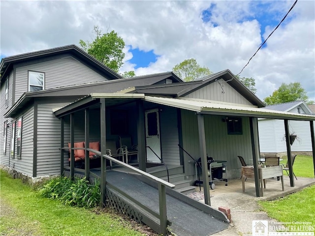 28 N Washington St, Randolph, NY 14772 - view of side of property featuring board and batten siding, a patio area, and a lawn
