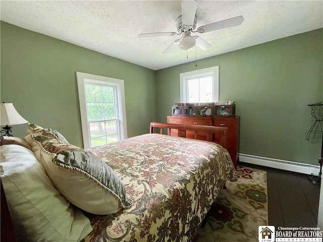 28 N Washington St, Randolph, NY 14772 - bedroom featuring baseboard heating, a textured ceiling, wood finished floors, baseboards, and a ceiling fan