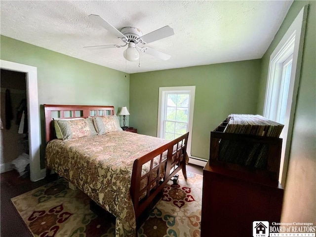 28 N Washington St, Randolph, NY 14772 - bedroom with baseboard heating, a ceiling fan, and a textured ceiling