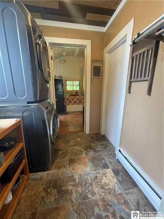 28 N Washington St, Randolph, NY 14772 - laundry room with estacked washer and dryer, dark stone finish floors, and a baseboard radiator