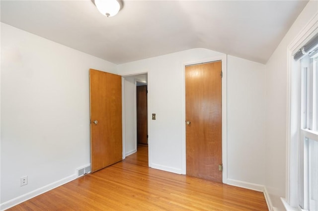 156 Rossiter Rd, Rochester, NY 14620 - unfurnished bedroom featuring light wood-type flooring, vaulted ceiling, and baseboards