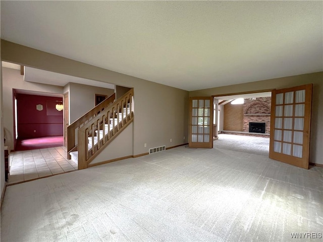 40 River Oaks Dr, Grand Island, NY 14072 - unfurnished living room with carpet, stairs, a fireplace, and baseboards