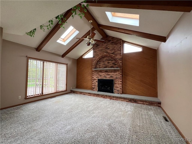 40 River Oaks Dr, Grand Island, NY 14072 - unfurnished living room featuring a skylight, ceiling fan, high vaulted ceiling, a brick fireplace, and carpet