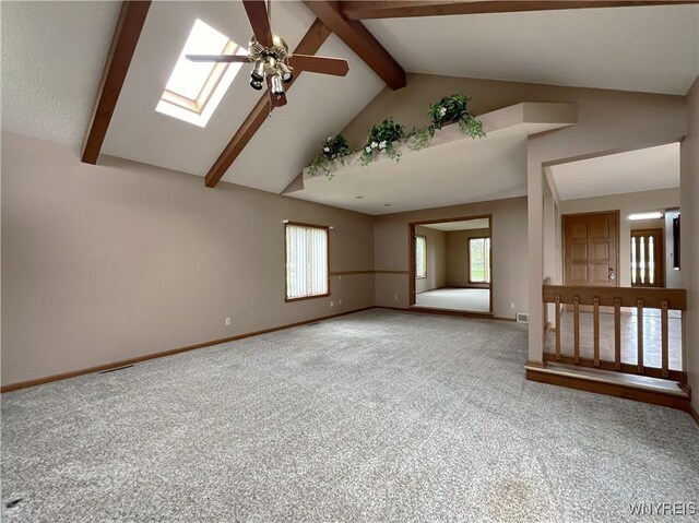 40 River Oaks Dr, Grand Island, NY 14072 - carpeted empty room with ceiling fan, a skylight, baseboards, beam ceiling, and high vaulted ceiling